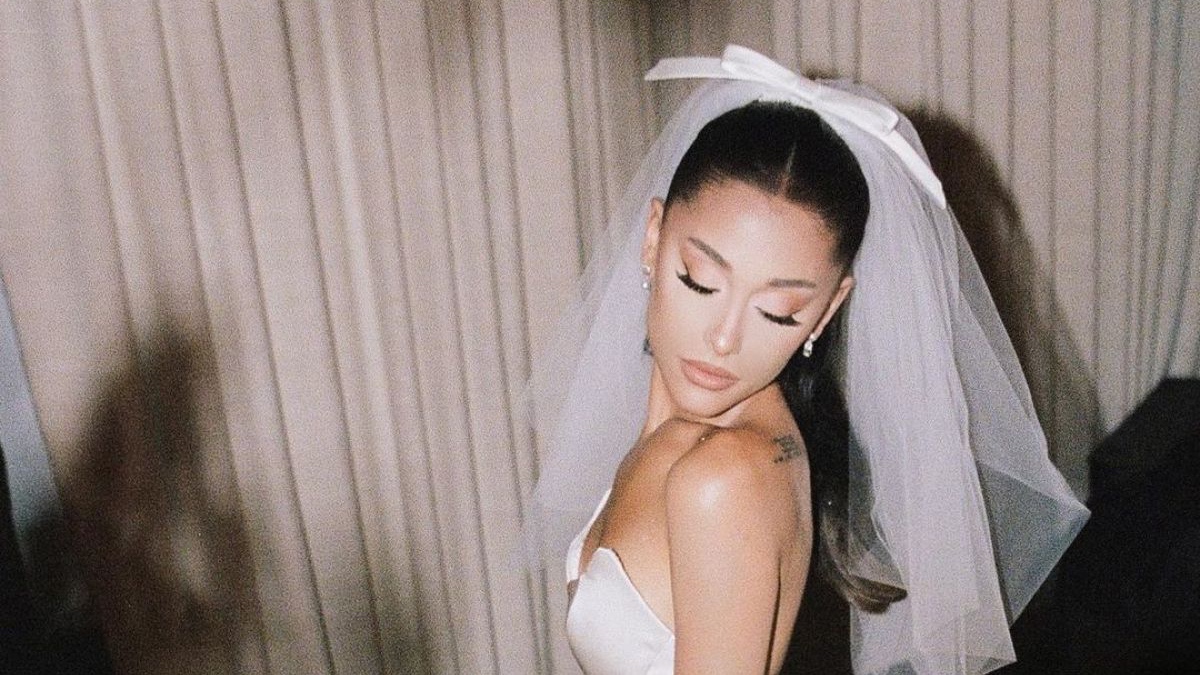 Bride wearing a custom silk column wedding dress with a vintage veil